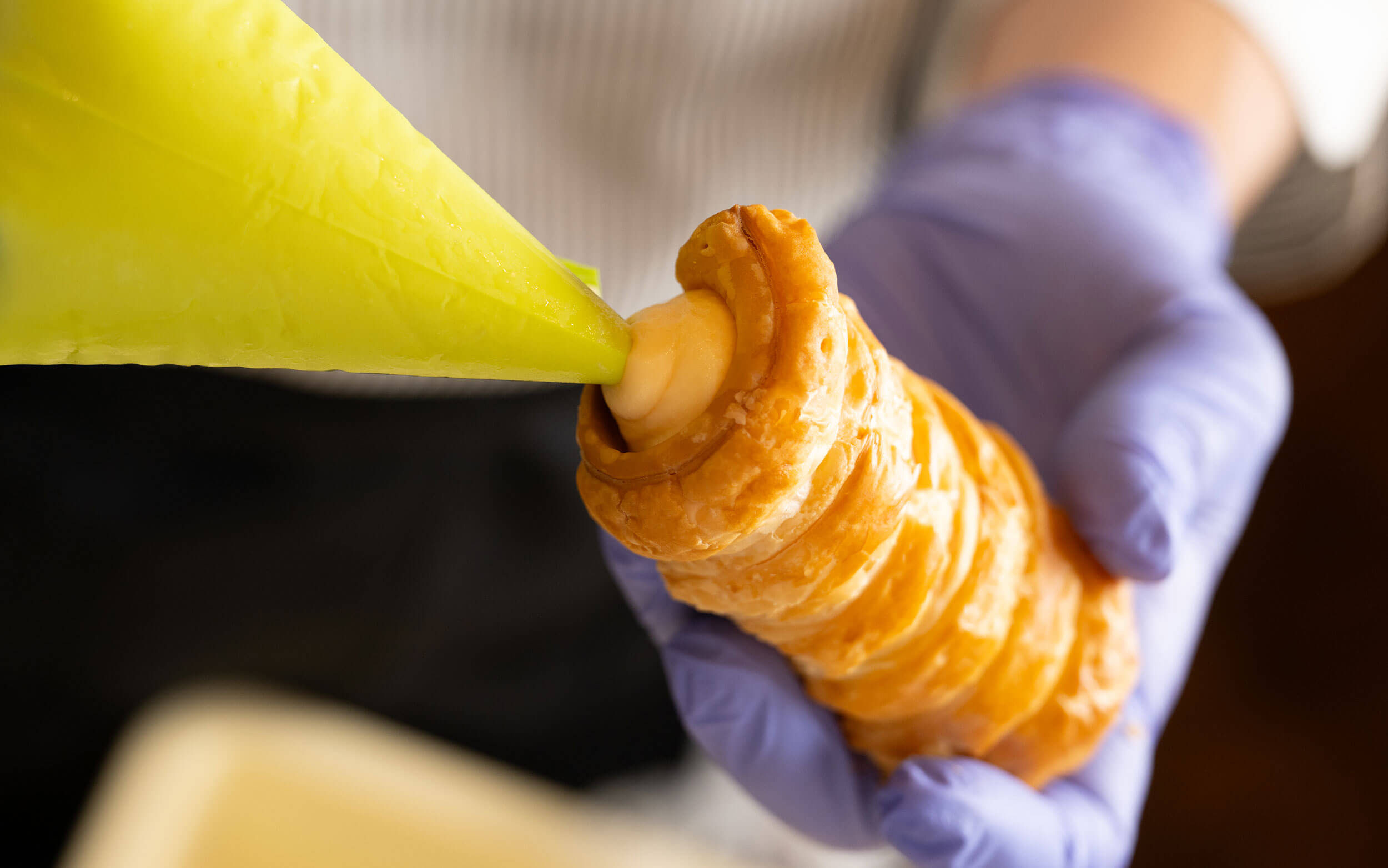 サクサクのコルネにクリームを絞り入れている様子